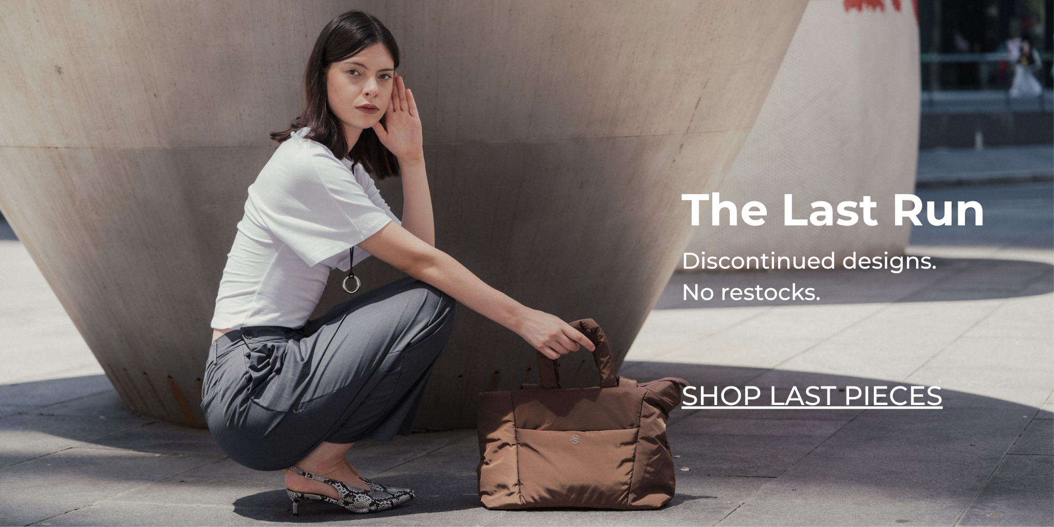 Female model wearing a neutral outfit with a cocoa brown Renkon Tobi Tote puffer bag, shown in an abstract mirrored effect against a minimal architectural setting.